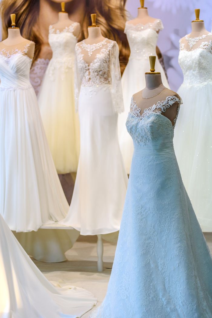 who-we-are A display of elegant white wedding dresses on mannequins showcasing lace and silk designs.