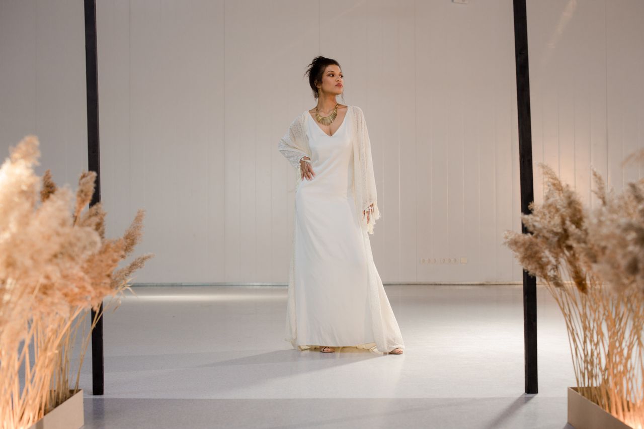 why-choose-us A stylish woman poses confidently in a flowing white dress, with warm lighting and elegant decor.